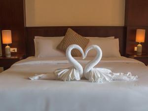two white swans making a heart on a bed at Lucky inn Residency in Pattaya South