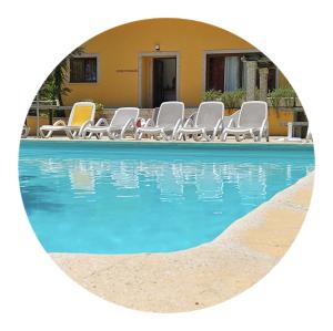 un grupo de sillas y una piscina frente a una casa en Casas das Guimbras, en Gerês