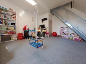 a play room with a swing in a attic at Rekreační Domek Litenčice na Jižní Moravě in LitenÄice
