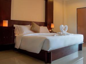 a bedroom with a large white bed with a heart on it at Lucky inn Residency in Pattaya South