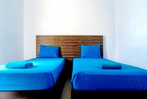 2 camas con almohadas azules en una habitación en RedDoorz at Sir G Hotel D'Mall Boracay en Boracay