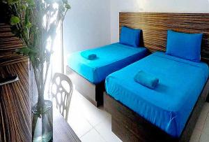 two beds with blue sheets in a room at RedDoorz at Sir G Hotel D'Mall Boracay in Boracay