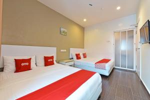 Cette chambre comprend 2 lits avec des oreillers rouges et blancs. dans l'établissement OYO 90853 New Soho Hotel, à Batu Caves