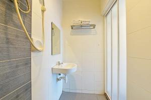La salle de bains blanche est pourvue d'un lavabo et d'une douche. dans l'établissement OYO 90853 New Soho Hotel, à Batu Caves