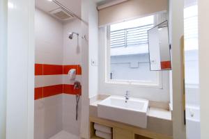 a bathroom with a sink and a window at Cleo Business Hotel Walikota Mustajab City Center in Surabaya