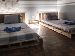 dos camas sentadas una al lado de la otra en una habitación en Napsule Suites en Dávao