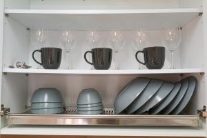a cupboard filled with dishes and wine glasses at private house JNP stay in Seoul