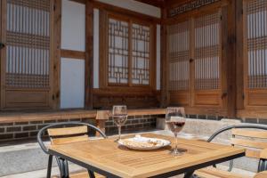 einen Holztisch mit zwei Gläsern Wein in der Unterkunft private house JNP stay in Seoul