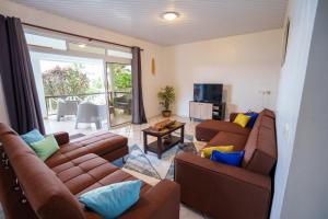 sala de estar con 2 sofás marrones y balcón en Noha Lodge, en Tohautu