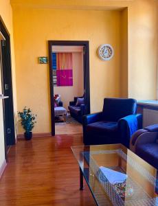 sala de estar con sofás azules y mesa de cristal en Old Ubani Apartment, en Tiflis
