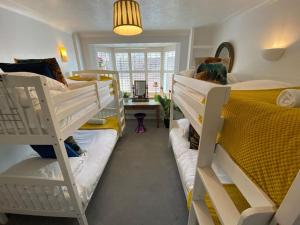um dormitório com 2 beliches e uma secretária em Brighton Parlourama with Hot Tub - Sleeps 18 em Brighton & Hove