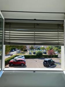 una ventana con vistas a los coches estacionados en un aparcamiento en Leaf Apartment, en Rávena