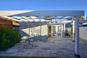 a pergola over a patio with a table and chairs at Macleay Cottage with plunge pool and local arts in Dubbo