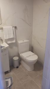a white bathroom with a toilet and a sink at Quattro Beachfront Sea View Ap 53 in Larnaka
