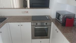 a kitchen with a stove and a microwave at Quattro Beachfront Sea View Ap 53 in Larnaka