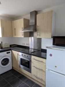a kitchen with wooden cabinets and a stove top oven at Superb 2 Bedroom Flat Tillicoultry in Tillicoultry