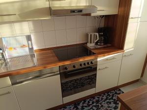 a kitchen with white cabinets and a stove top oven at Ferienwohnung zum Glück in Bad Kissingen