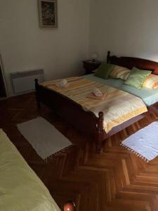 a bedroom with a large bed with a wooden floor at Room in Sukosan with balcony, air conditioning, WiFi 5188-2 in Sukošan
