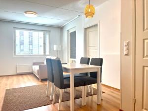 uma sala de jantar com mesa e cadeiras em Guest apartment with view and terrace, Vuosaari, Helsinki, self check-in em Helsinque