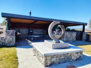 a statue in front of a stone building at LH Twizel Fountain Retreat in Twizel