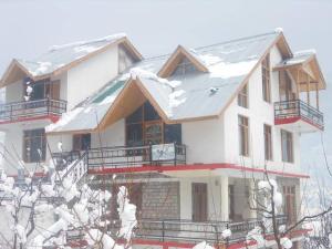a large house with snow on the roof at The Cozy Nook - Manali in Manāli