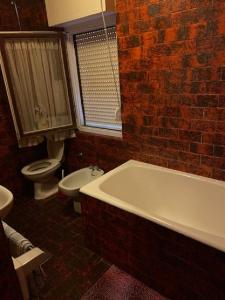 a bathroom with a white tub and a brick wall at Room in Sukosan with balcony, air conditioning, WiFi 5188-6 in Sukošan