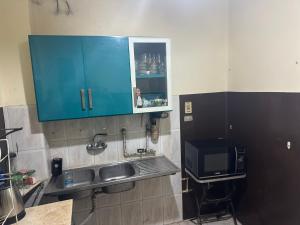 a kitchen with a sink and a blue cabinet at Beautiful apartment in the heart of cairo in Cairo