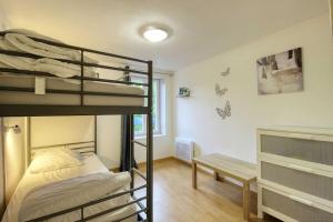 a bedroom with two bunk beds and a bench at Aux volets bleus in Badonviller