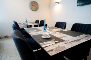 una sala de conferencias con mesas y sillas y un reloj en AP Hotel Mannheim Viernheim, en Viernheim