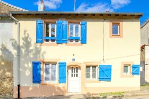 a white house with blue shutters and a door at Aux volets bleus in Badonviller