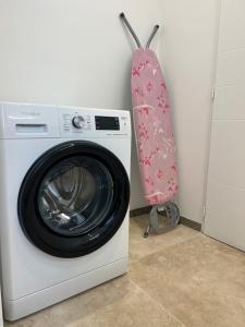 a washing machine with a pink towel hanging on a wall at Chambre de charme n2 in Grimaud