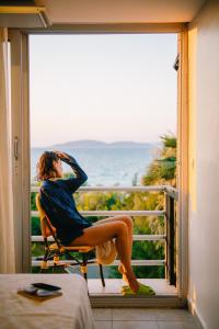 チェシメにあるRooms Smart Luxury Hotel & Beachの窓を見下ろす椅子に座る女性