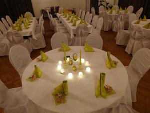 um quarto com mesas brancas e cadeiras brancas com velas em Hotel Schützenhaus Lenzen em Lenzen