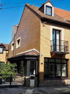 een bakstenen huis met een balkon ernaast bij Belle Villa au Coeur du Touquet in Le Touquet-Paris-Plage