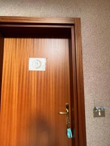 une porte en bois avec une étiquette dans l'établissement Appartamento Vacanze Da Dilly, à Tirano