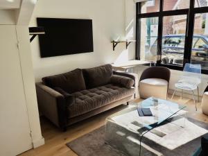 een woonkamer met een bank en een tv bij Belle Villa au Coeur du Touquet in Le Touquet-Paris-Plage