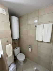 y baño con aseo, lavabo y toallas. en Varna City Apartment, en Varna
