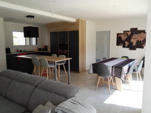 een woonkamer en een keuken met een bank en een tafel bij Maison à 100m de la Mer in Saint-Hilaire-de-Riez