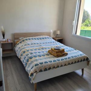 een slaapkamer met een bed met een deken erop bij Maison à 100m de la Mer in Saint-Hilaire-de-Riez