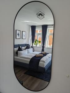 - un miroir reflétant un lit dans une chambre dans l'établissement ViLiPa-Apartments modernes Wohnen mitten im Zentrum am Bachhaus, à Eisenach