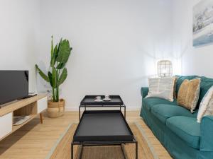 a living room with a blue couch and a coffee table at Matarolux24 in Mataró