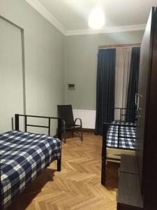 a bedroom with two beds and a chair in it at For Daily Rent in Tbilisi City