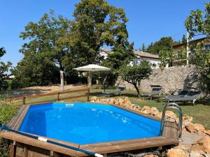 - une piscine dans une cour avec un parasol dans l'établissement Villa Nogarola - apartment with private pool and garden, à Costermano