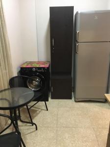 a small kitchen with a refrigerator and a table at For Daily Rent in Tbilisi City