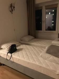 two beds in a bedroom with a bag sitting on them at Przytulny apartament z bezpłatnym parkingiem in Olsztyn