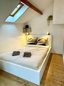 a bedroom with a large white bed with two pillows at Four à pain in Sprimont