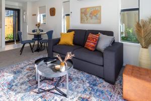 a living room with a couch and a table at Central City Escape 1 Bed 1 Bath near Hagley Park in Christchurch +28 photos