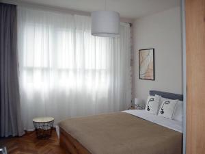 a bedroom with a large bed and a window at Specious Modern Apartment in Sofia