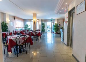un ristorante con tavoli e sedie con tovaglia rossa di Hotel Cristina a Rimini