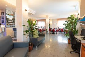una hall di un ristorante con tavoli e sedie di Hotel Cristina a Rimini